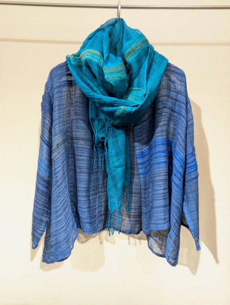 青と緑のストールを羽織った絹のコート、壁に掛かっている。